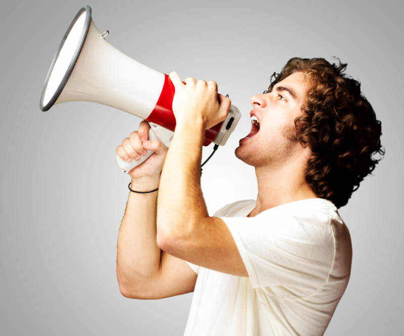 Pessoa com megafone falando sobre a importância de analisar o edital